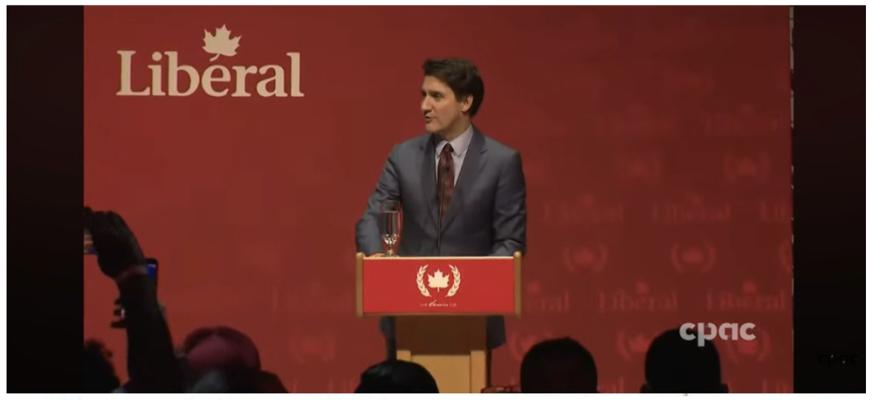 Canada's Prime Minister Trudeau standing at a dias emblazoned with a communist symbol