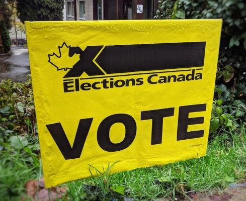 Yellow Elections Canada lawn sign that says 'vote' indicating a polling station for a federal election