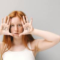 Woman with "yes" and "no" written on the palms of her upturned hands