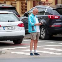 Man gazing at a phone while standing in traffic