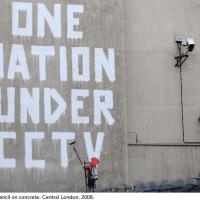 Banksy stencil on a concrete wall that says "One Nation Under CCTV". London. 2008.