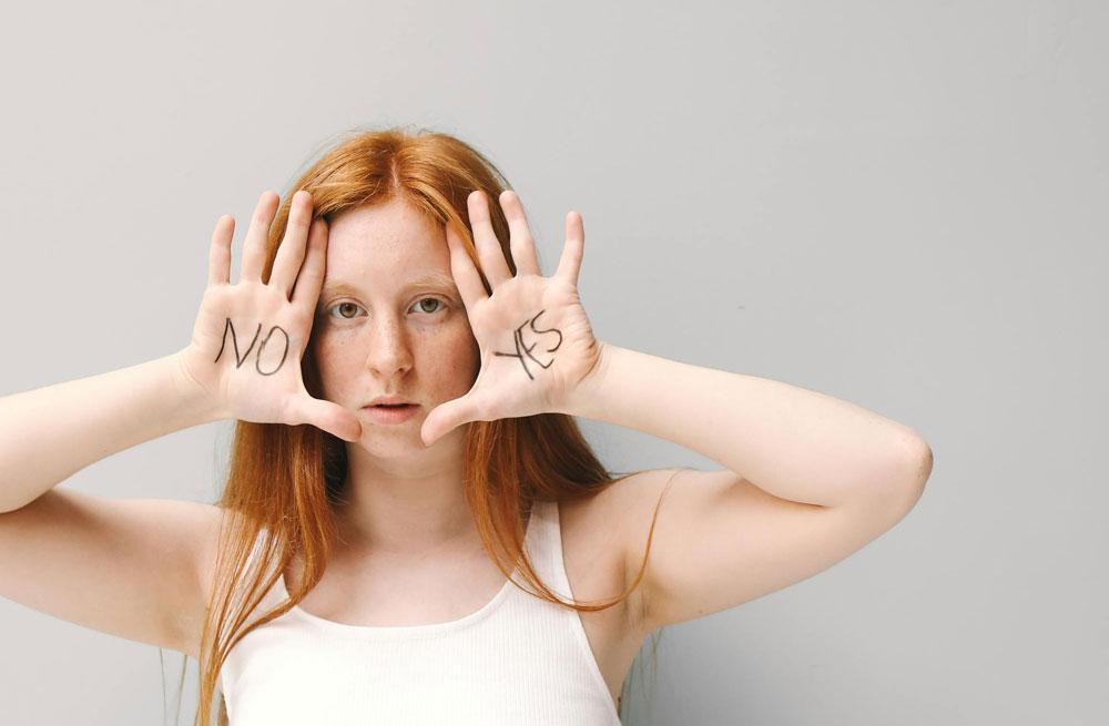 Woman with "yes" and "no" written on the palms of her upturned hands